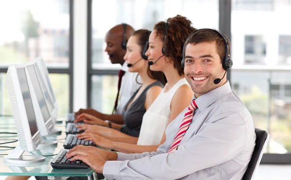 Smiling businessman working in a call center — Stock Photo, Image