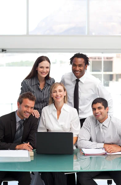 Glimlachend businessteam samen met een laptop — Stockfoto