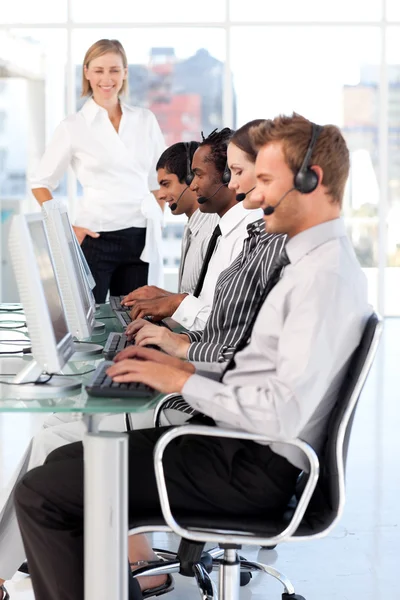 Smiling female leader managingher team in a call center — Stock Photo, Image