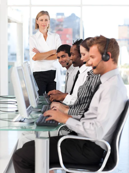 Lachende vrouwelijke leider managingher team in een callcenter — Stockfoto