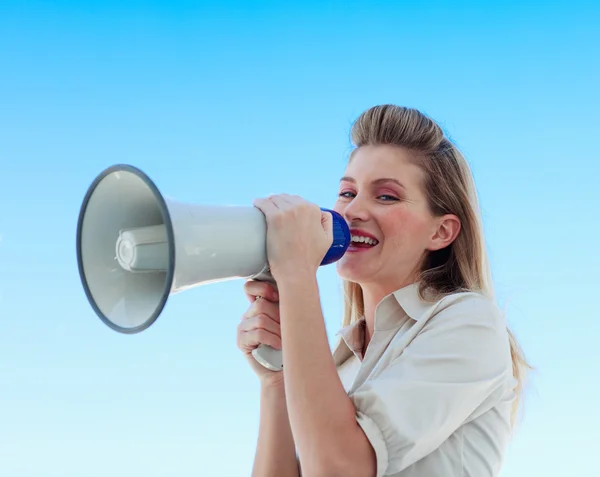 Beautiful businesswoman shouting through megaphone — Stock Photo, Image