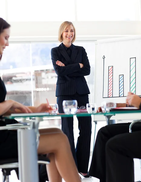 Приваблива бізнес-леді посміхається своїм колегам на зустрічі — стокове фото
