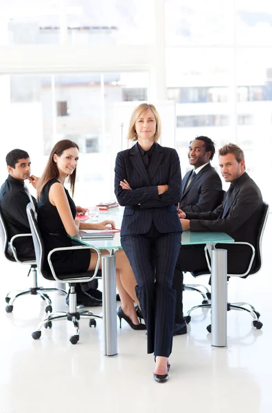 Empresária séria com braços dobrados em uma reunião — Fotografia de Stock