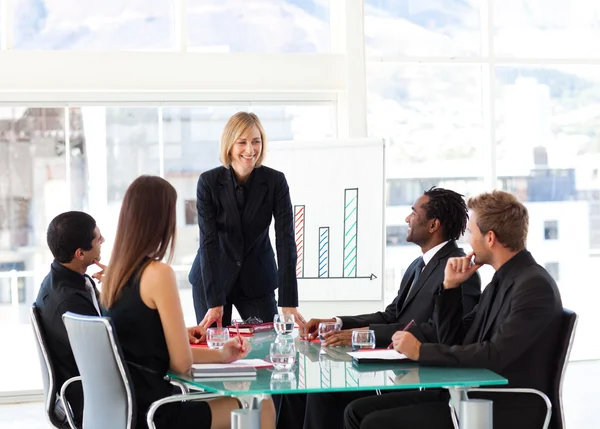 Empresaria sonriendo a sus colegas en una reunión — Foto de Stock