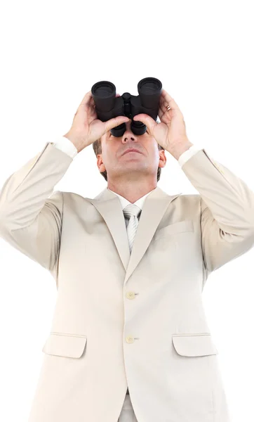 Serious businessman looking through binoculars in front of the camera — Stock Photo, Image