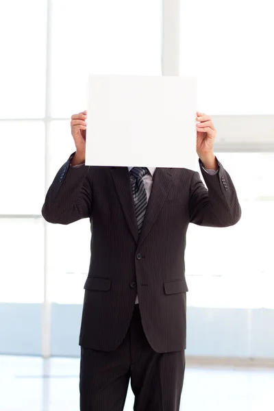 Homem segurando um grande cartão de visita na frente de sua cara — Fotografia de Stock