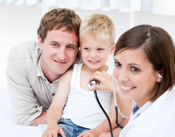 Portrait of beautiful female doctor examining a little boy with — Stock Photo, Image