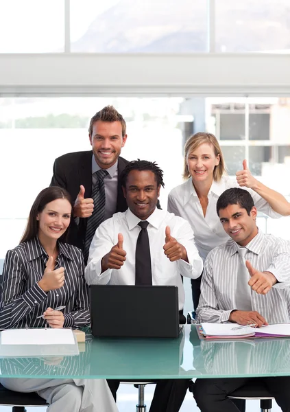 Businessteam with thumbs up smiling at the camera Stock Photo