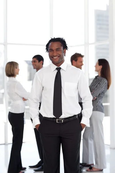 Portrait of an ethnic male leader with his team in background — Stock Photo, Image
