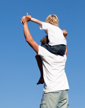 Son sitting on his father's shoulders clipart