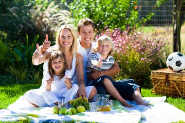 Happy family having a picnic with thumbs up clipart