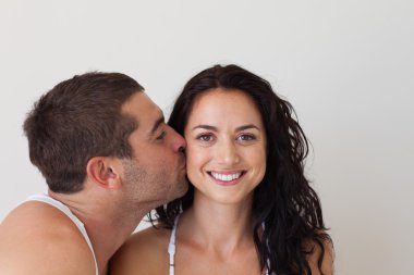 Portrait of an affectionate man kissing his wife clipart