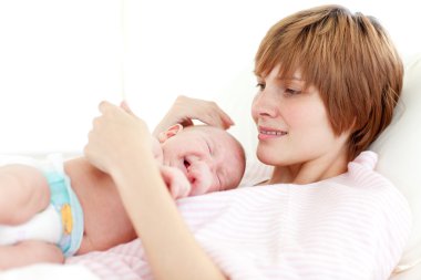 Mother attending to her newborn baby clipart