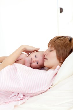 Patient relaxing with her newborn baby in bed clipart