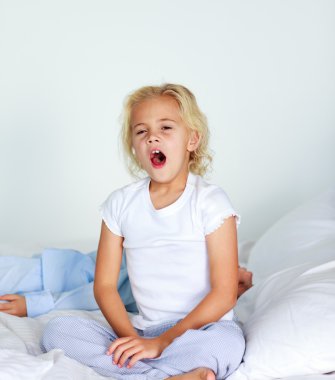 Beautiful daughter yawning in bed clipart