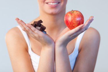 Close-up of woman showing chocolate and apple focus on chocolate and apple clipart