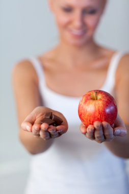 Blonde woman showing chocolate and apple focus on chocolate and apple clipart