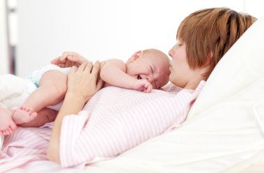 Woman holding her newborn baby clipart