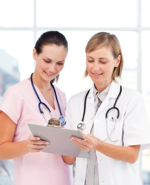 Nurse and doctor reading a medical report clipart