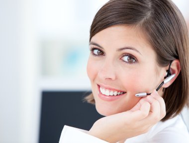 Cute businesswoman talking with clients in front of her computer clipart