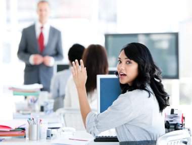 Portrait of a interrested businesswoman raising her hand clipart