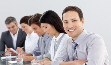 Young businessman in a meeting with his team clipart