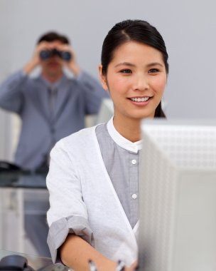 Self-assured asian businesswoman at a computer clipart