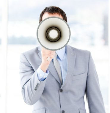 Portrait of an young businessman using a megaphone clipart