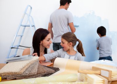 Smiling family decorating their new home clipart