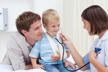 Female doctor playing with a little child clipart