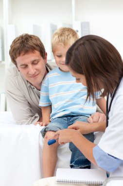 A doctor checking little boy's reflex clipart