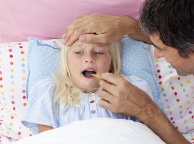 Father checking his daughter's temperature with a thermometer clipart