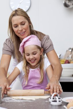 Mother and daughter baking cookies in the kitchen clipart