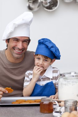 Father and son eating home-made cookies clipart