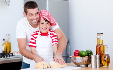 Portrait of a father and his son preparing a meal clipart