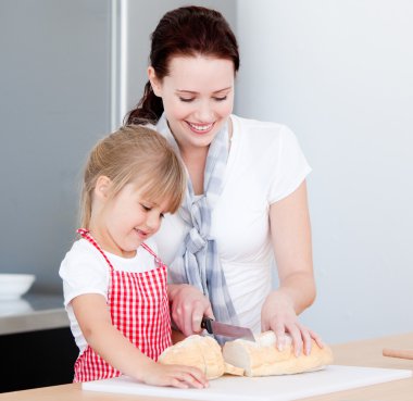 Portrait of a smiling mother and his daughter preparing a meal clipart