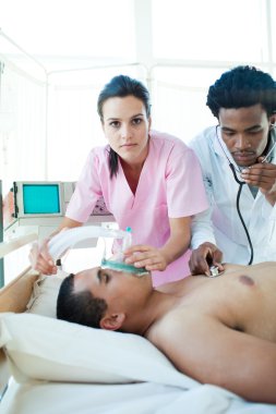 A doctor and a nurse resuscitating a male patient clipart