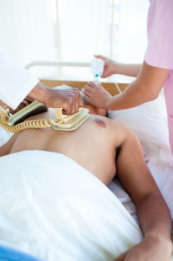 A doctor performing a CPR with a defibrillator on a patient clipart