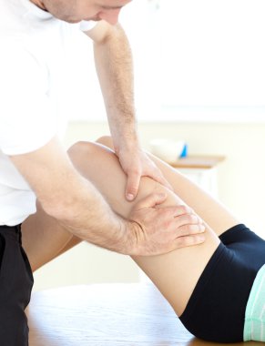 Young woman receiving a leg massage clipart