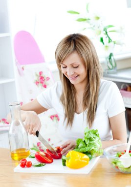 Cheerful woman preparing a healthy meal in the kitchen clipart