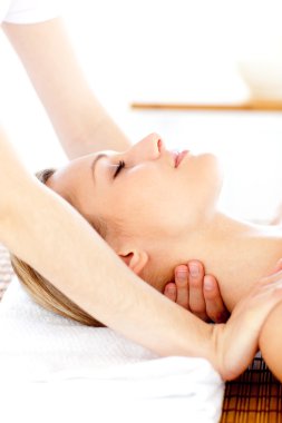 Portrait of a young woman having a massage clipart