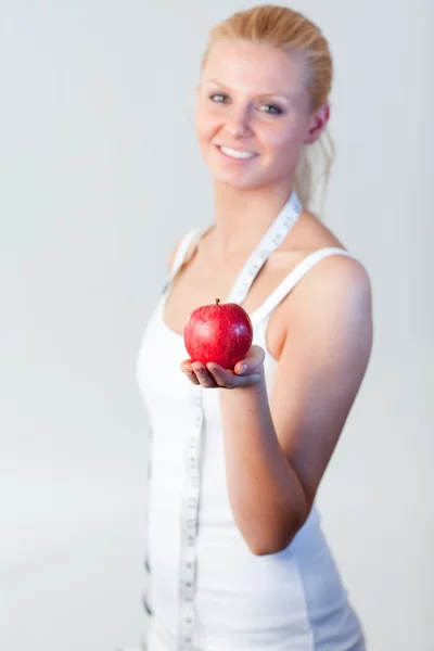 Portrait of a woman holding an apple with focus on apple — Stock Photo, Image