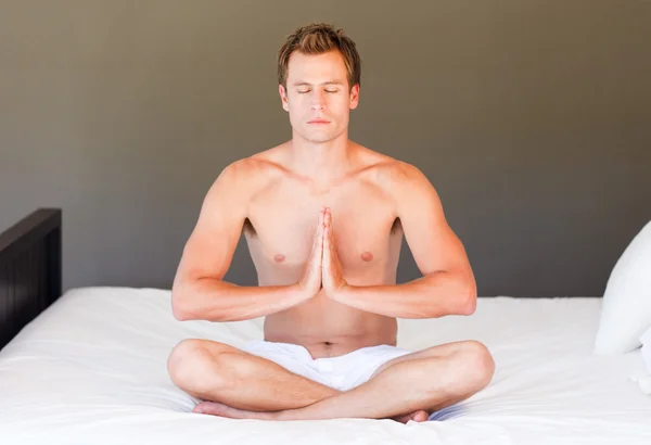 Jonge jongen doet yoga op bed met clossed ogen — Stockfoto