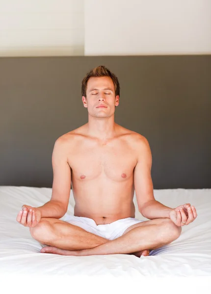 Handsome man doing meditation on bed — Stock Photo, Image