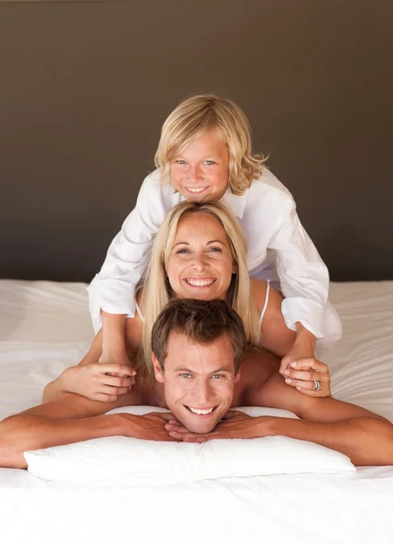 Portret szczęśliwych rodziców i dzieci, zabawy w łóżku — Zdjęcie stockowe
