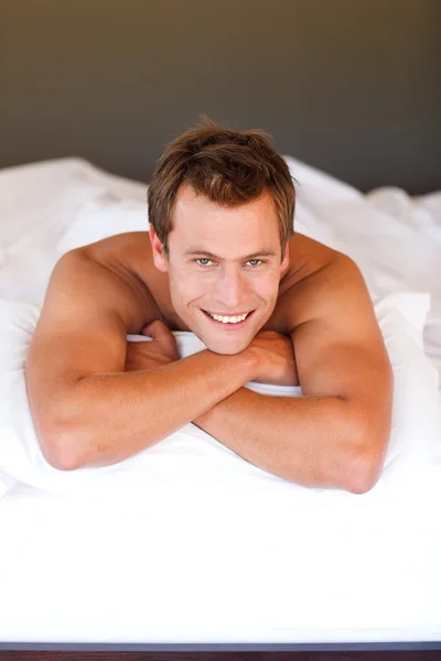 Junger Mann entspannt sich im Bett — Stockfoto