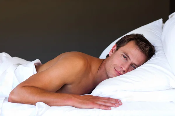 Yakışıklı erkek yatakta rahatlatıcı — Stok fotoğraf