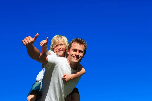 Son on father's back with thumbs up — Stock Photo, Image