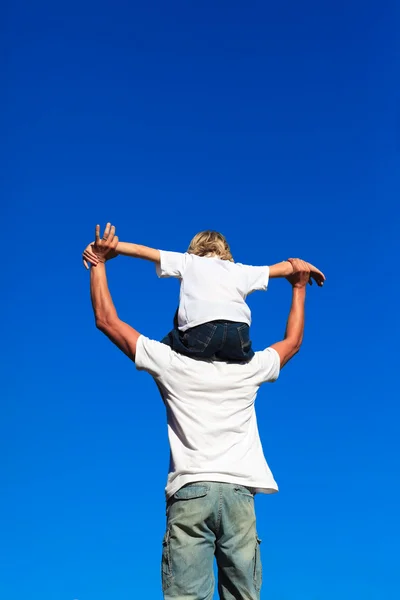 Zoon zittend op zijn vaders schouders — Stockfoto
