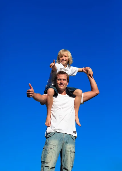Kid on man's shoulders with thumbs up — Stock Photo, Image